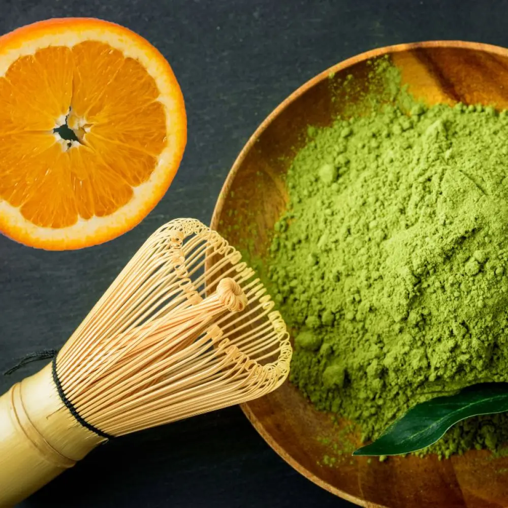 Matcha_Latte_Pulver_mit_Besen_und_Orangenscheibe-631642_1024x1024